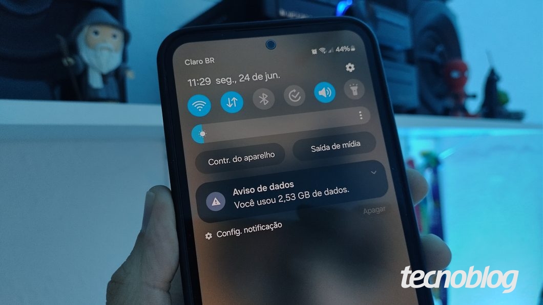 Imagem mostra uma mão segurando um celular exibindo a notificação de "Aviso de dados"